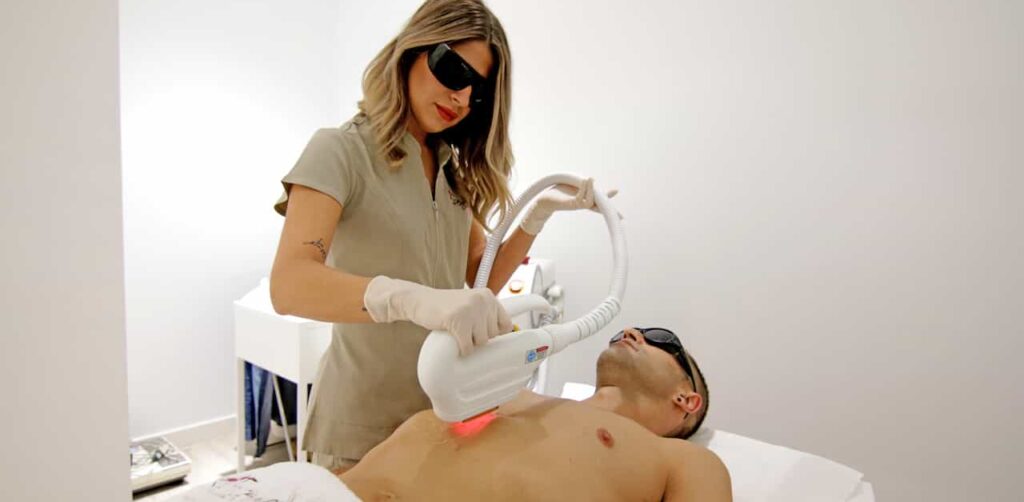 esteticista haciendo la depilación láser a un paciente en Donostia